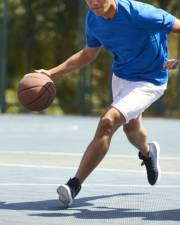 A man dribbling a basketball on a basketball court